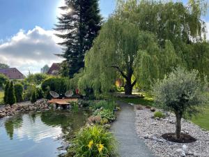 a park with a pond and a bench and trees at Ferienwohnung "MeerTied" - Ankommen und Entspannen in Klausdorf Mecklenburg Vorpommern