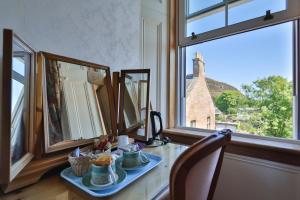 a room with a table with a plate of food and a window at Rosehall Hotel in Edinburgh