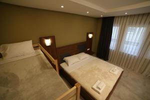 1 dormitorio con 2 camas y ventana en Hotel Centrum, en Kosovska Mitrovica