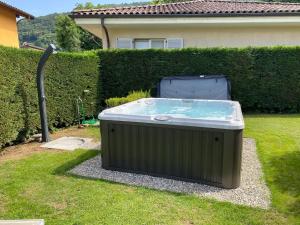 a hot tub sitting in the grass in a yard at Cartiera in Cannobio