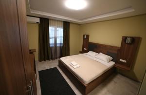 a bedroom with a bed with white sheets and pillows at Hotel Centrum in Mitrovicë