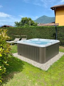 a hot tub in a yard next to a hedge at Cartiera in Cannobio
