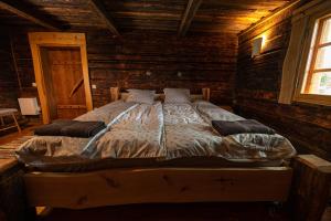 a bedroom with a bed in a log cabin at Pruuli Vahtra puhkemaja in Kraavi