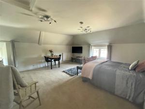 a bedroom with a bed and a table and a chair at The Dairyman Suite in Dorchester