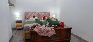 1 dormitorio con 1 cama con almohadas verdes y rosas en Lithos house pt 1p e 2p, en Monopoli