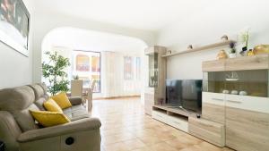 a living room with a couch and a television at KORALLIA GUESTHOUSE Castle Harbour in Los Cristianos