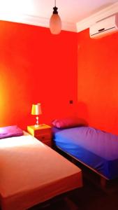 2 camas en una habitación con paredes rojas en The Guest House Bin Elouidane, en Bine el Ouidane