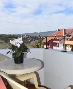 a table with a vase of flowers on a balcony at Guest House DARIS-APHRODEYA Къща за Гости ДАРИС-АФРОДЕЯ in Sozopol