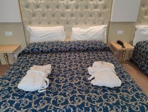 two white towels are laying on a bed at Hotel Ambassador in Rimini