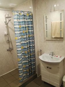 a bathroom with a shower curtain and a sink at Вила Полина in Varna City