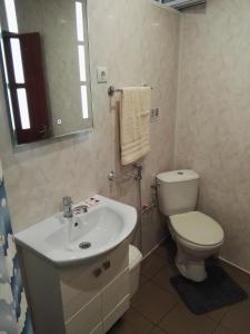 a bathroom with a white toilet and a sink at Вила Полина in Varna City +9 photos