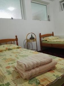 1 dormitorio con 2 camas y una mesa con toallas en Вила Полина en Varna