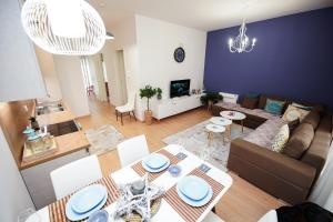 ein Wohnzimmer mit einem Sofa, einem Tisch und Stühlen in der Unterkunft ROGA Apartment Valamar in Hamallë