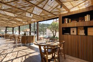 a restaurant with tables and chairs and a large window at Hotel Casamar in Llafranc