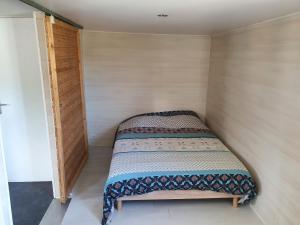 um pequeno quarto com uma cama num quarto em Chalet au cœur de la foret de Rambouillet em Les Bréviaires