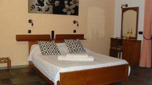 Schlafzimmer mit einem Bett mit einem Kopfteil aus Holz und einem Spiegel in der Unterkunft Captain George's Apartments in Patitiri