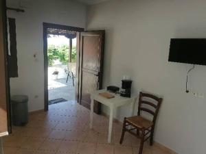 a room with a table and a chair and a door at Porto Almira Beachfront Apartments in Nikiti