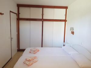 a bedroom with a white bed with two towels on it at Apartamento en Playa del Inglés Los Mangos in Playa del Ingles