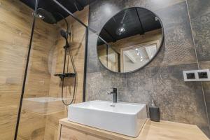 a bathroom with a sink and a mirror at Wycisznia - drewniane domki całoroczne in Gierałtowiczki +20 photos