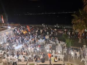 una grande folla di persone sedute sulle sedie di notte di Loft Magna Grecia Reggio Calabria Centro Storico a Reggio di Calabria