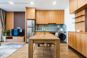 a kitchen with wooden cabinets and a wooden table at Five Star Westlake 1st-4th Floors Hotel & Serviced Apartment in Hanoi