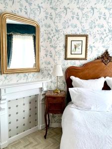 - une chambre avec un lit et un miroir dans l'établissement Maison Trianon 1928, à Quiévrechain