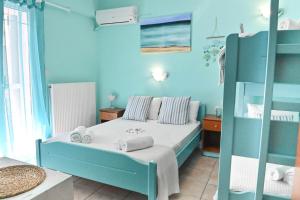 a blue bedroom with a bed with towels on it at El Greco Nei Pori in Nei Poroi