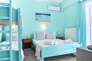 a bedroom with blue walls and a bed with towels on it at El Greco Nei Pori in Nei Poroi