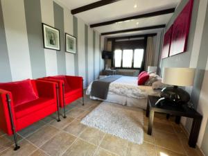 a bedroom with a bed and a red chair at A Lastriña in Trives
