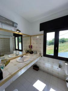 a bathroom with two sinks and a large window at A Lastriña in Trives