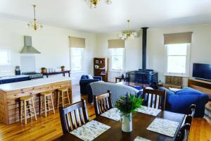 ein Wohnzimmer mit einem Tisch und einer Küche in der Unterkunft Pound Hill Cottage in Miners Rest
