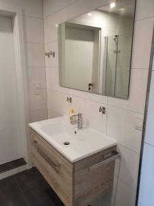 uma casa de banho com um lavatório e um espelho em Ferienwohnung Relax em Tettnang