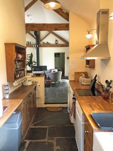 a large kitchen with wooden counter tops and a living room at Drovers Retreat in Llandrindod Wells