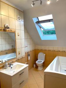 łazienka z umywalką, toaletą i oknem dachowym w obiekcie Hostel Wilanów w Warszawie