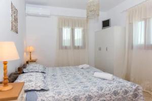 Villa Galante, (croft house nearby the sea) في ناكسوس تشورا: غرفة نوم بسرير وطاولة مع مصباح