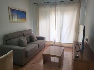 uma sala de estar com um sofá e uma mesa de centro em ¡Apartamento en primera línea con terraza y cerca de la piscina comunitaria! em Vera