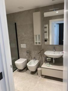 a bathroom with two sinks and a toilet and a mirror at Junior Suite agli Archi in Torri del Benaco