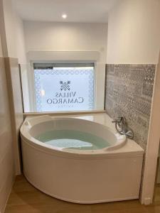 a large bath tub in a bathroom with a window at Villas Camargo.suites in Camargo