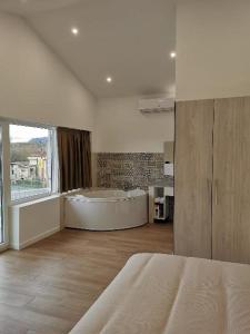 1 dormitorio con bañera grande y ventana grande en Villas Camargo.suites, en Camargo