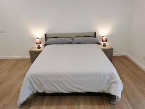 a bedroom with a large white bed with two night stands at Villas Camargo.suites in Camargo
