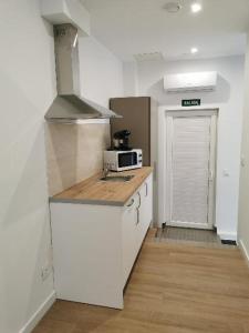 a kitchen with a stove and a microwave on a counter at Villas Camargo.suites in Camargo