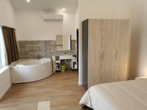 a white bathroom with a tub and a bed at Villas Camargo.suites in Camargo