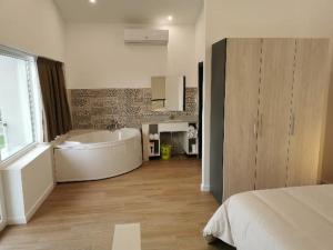 a large bathroom with a tub and a bed at Villas Camargo.suites in Camargo