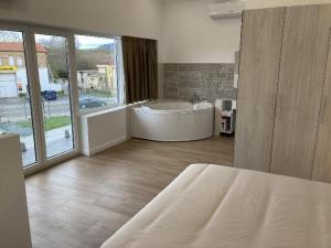 a large bathroom with a tub and a large window at Villas Camargo.suites in Camargo