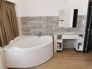 a bathroom with a white tub and a sink at Villas Camargo.suites in Camargo
