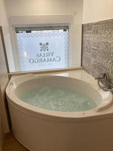 a bath tub with a sign in a bathroom at Villas Camargo.suites in Camargo