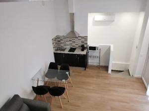 a living room with a table and chairs and a kitchen at Villas Camargo.suites in Camargo