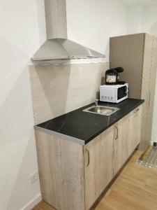a kitchen with a sink and a microwave on a counter at Villas Camargo.suites in Camargo