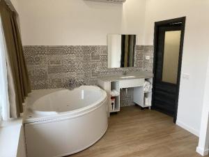 a bathroom with a large tub and a sink at Villas Camargo.suites in Camargo
