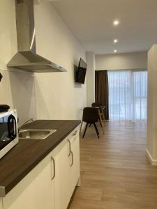 a kitchen with a sink and a stove top oven at Villas Camargo.suites in Camargo